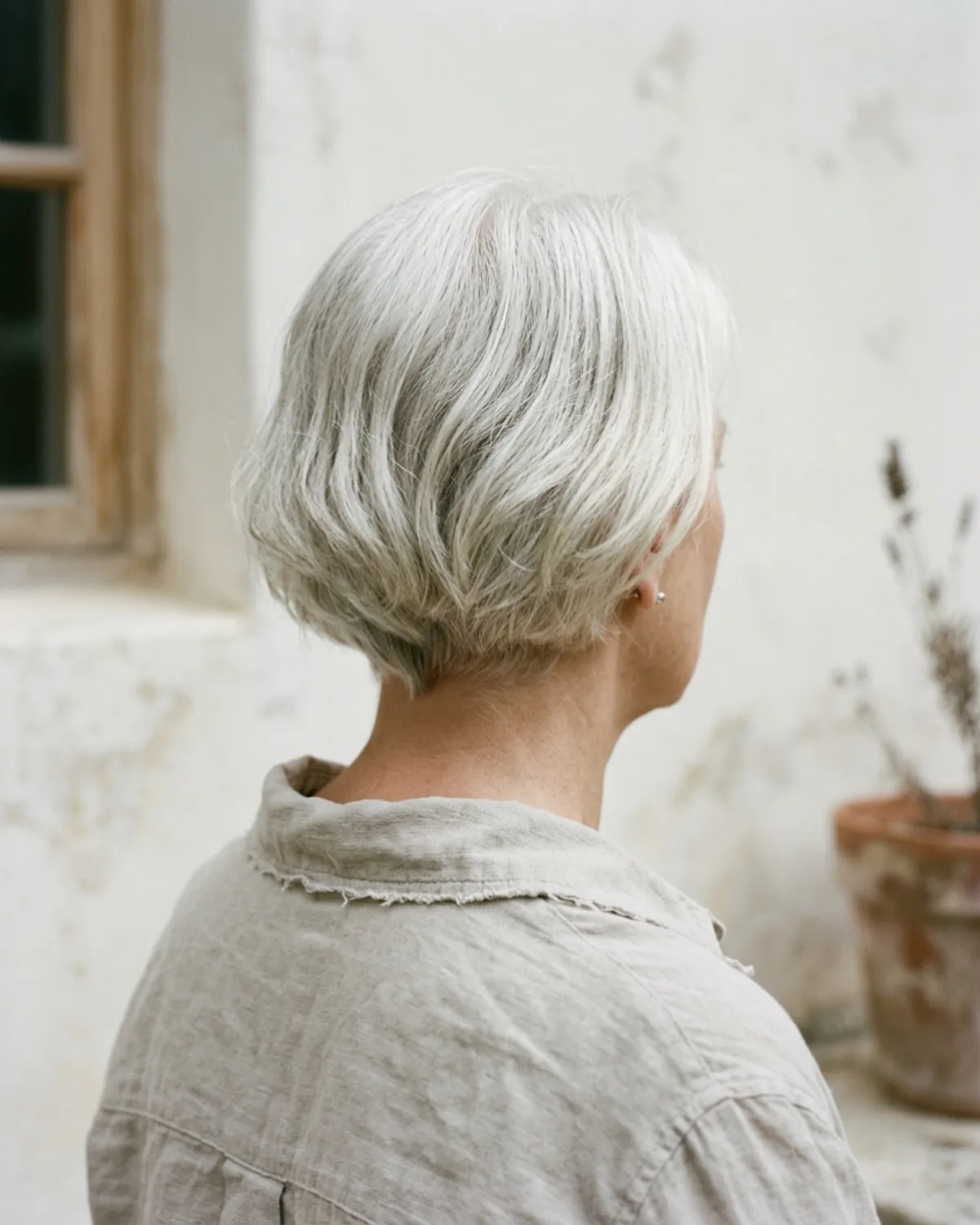 Detalle de un corte bob con movimiento sobre pelo blanco natural, peinado con dedos, sin alisar.